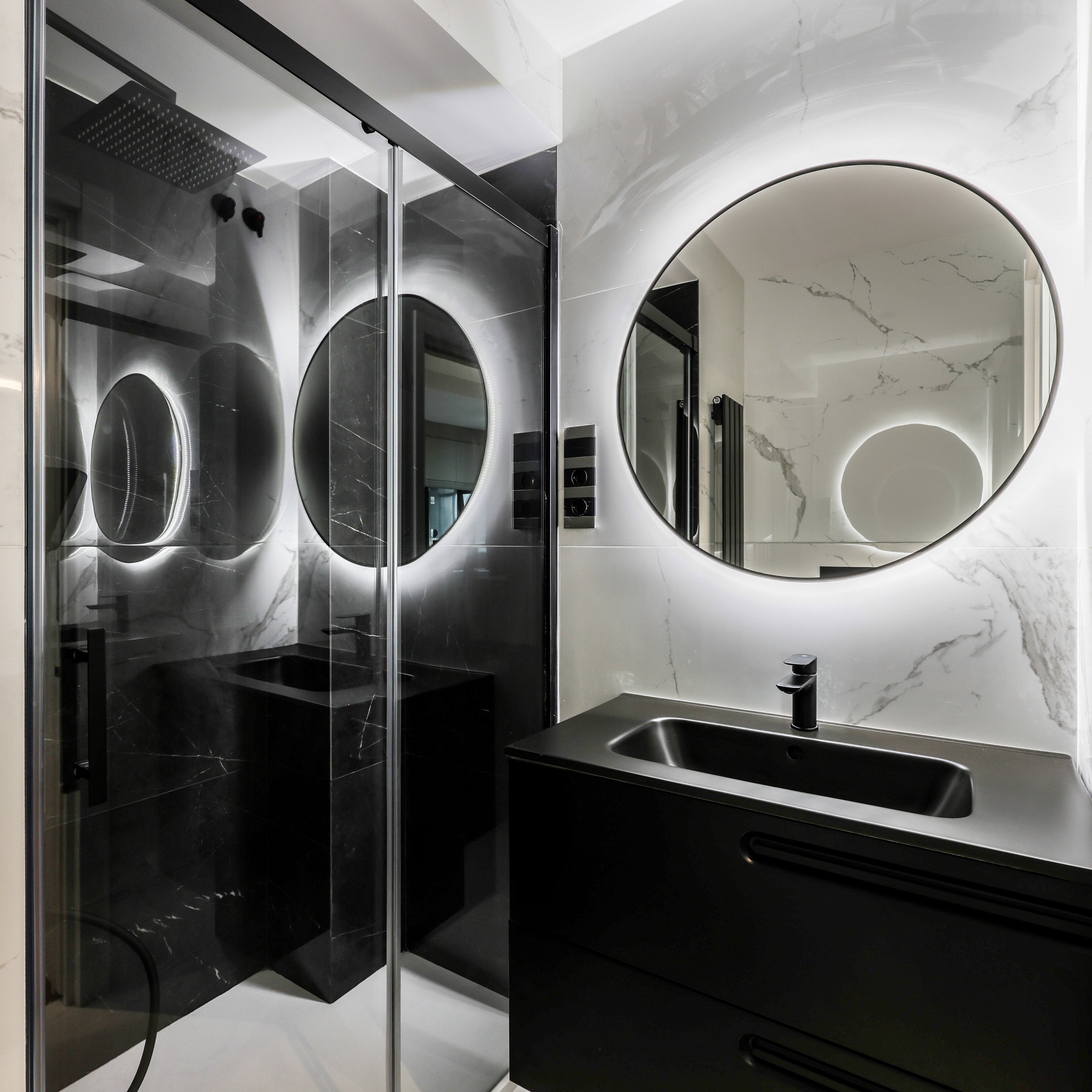 Baño con ducha de obra y mampara de vidrio, mármol negro
