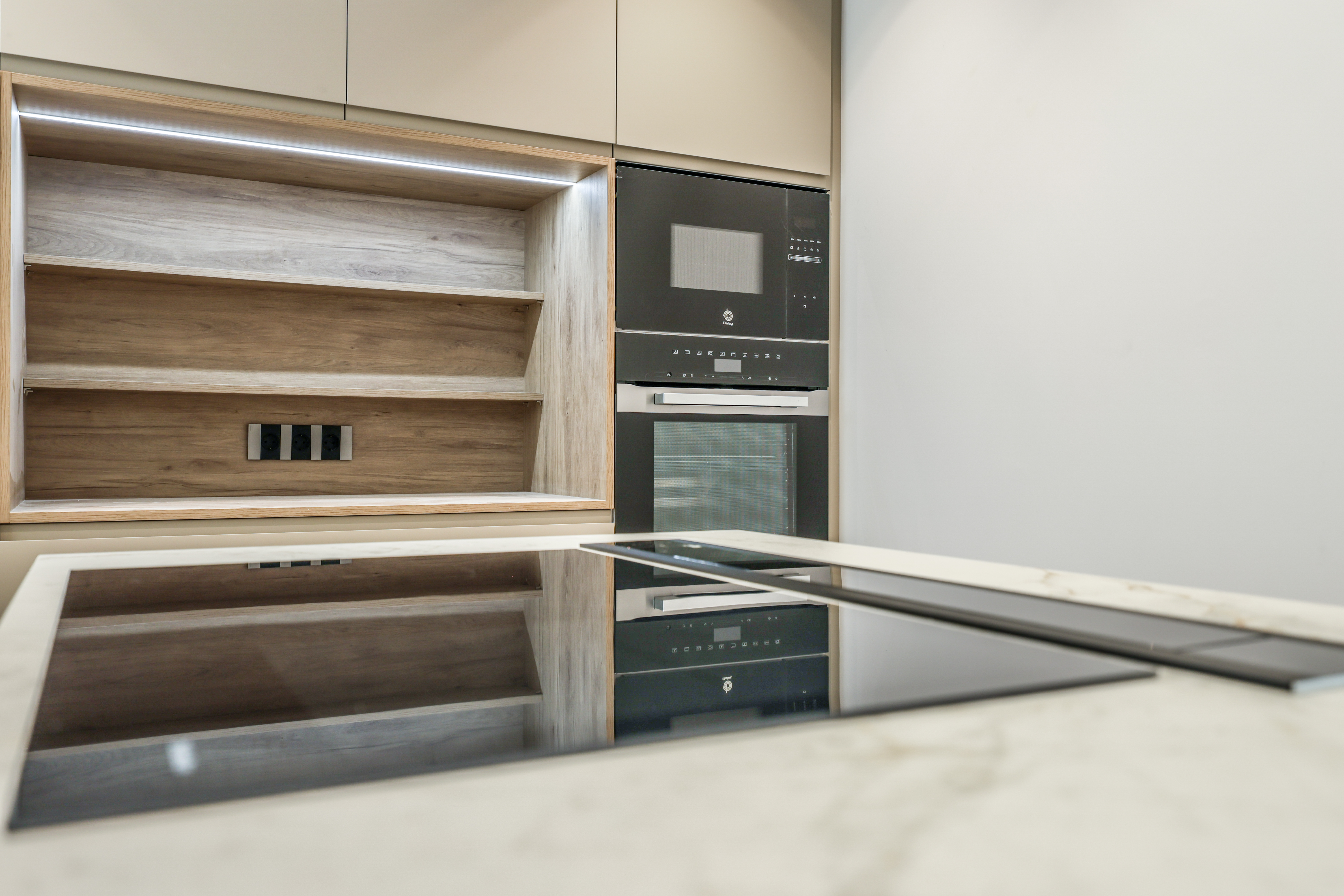 Detalle de mueble de cocina con estantería abierta de madera y electrodomésticos integrados