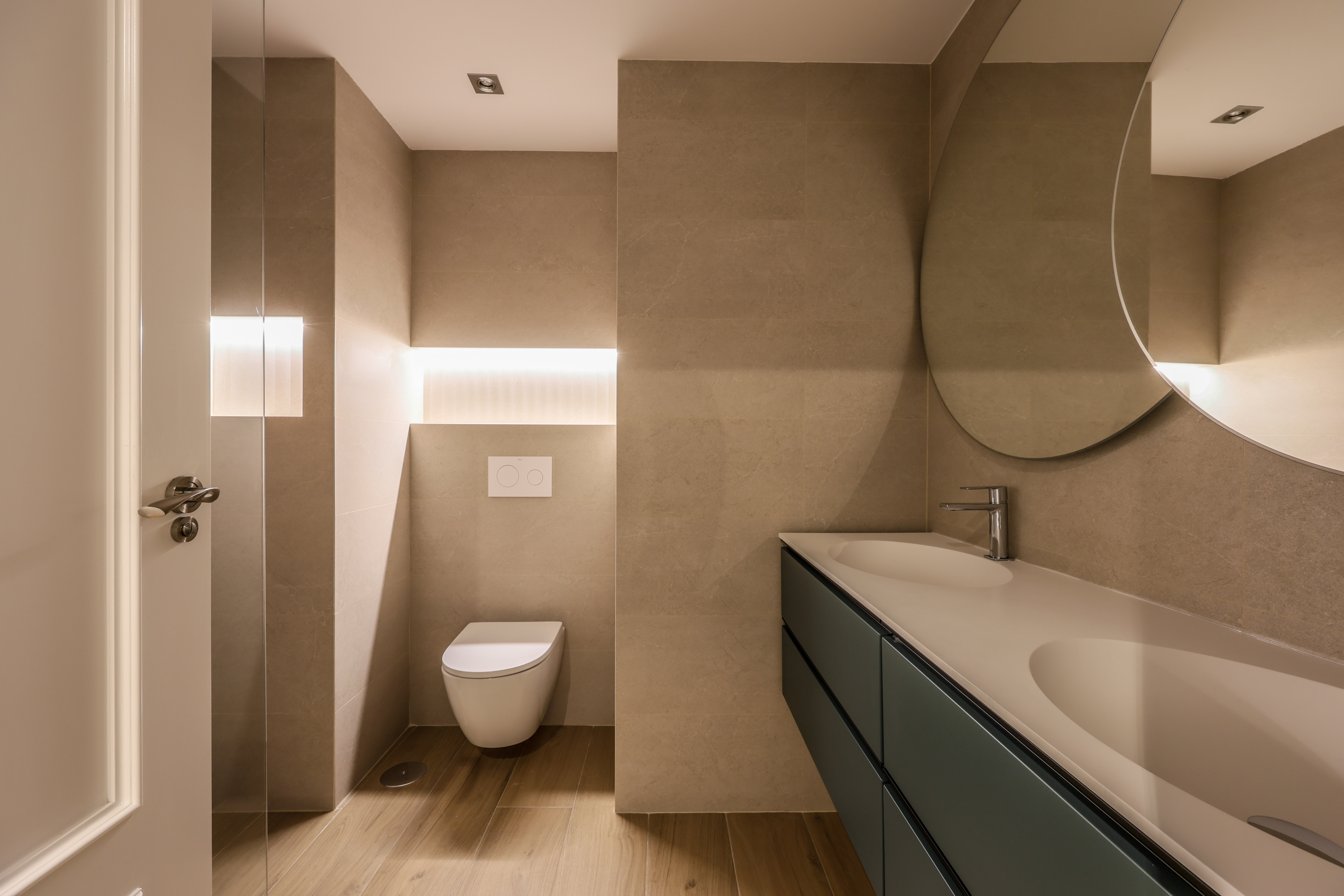 Baño beige lateral con inodoro suspendido y nicho de almacenaje